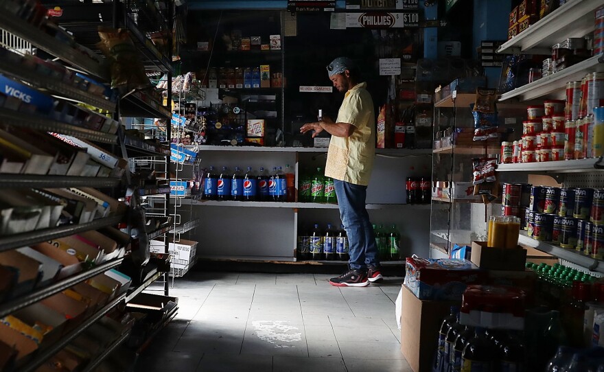 A person visits a Miami store that doesn't have electricity on Tuesday. Much of Florida was without power two days after Hurricane Irma battered the state.