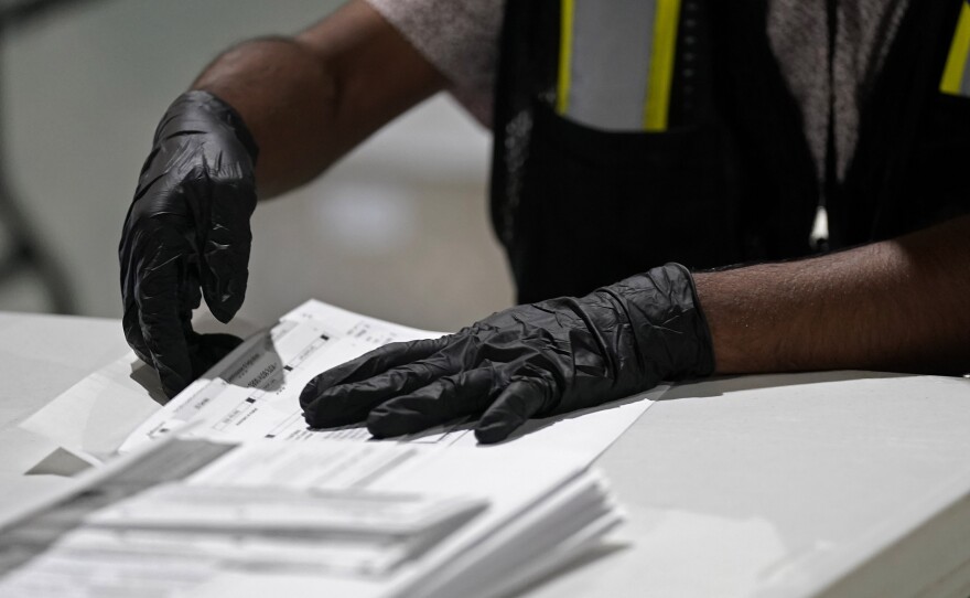 In this Sept. 3, 2020, file photo, a worker prepares absentee ballots for mailing at the Wake County Board of Elections in Raleigh, N.C.