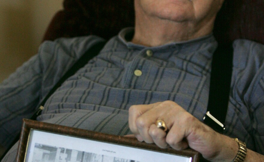 Elwin Wilson holds a photo of the mob he was part of in 1960.