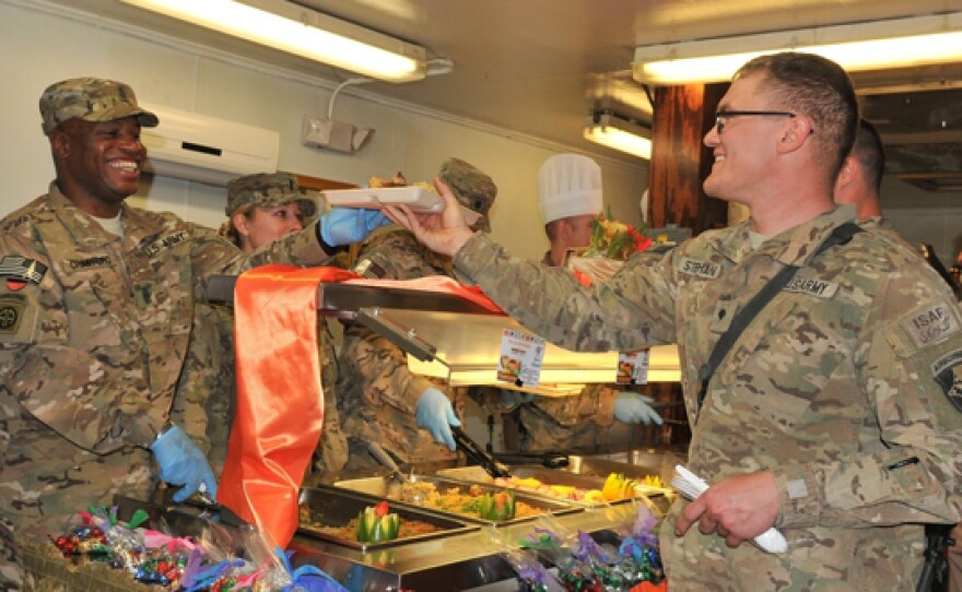 Army Command Sgt. Maj. Christopher T. Crawford serves Thanksgiving dinner to Army Spc. Victor W. Stephans Nov. 28, 2013, at Bagram Air Field, Afghanistan.