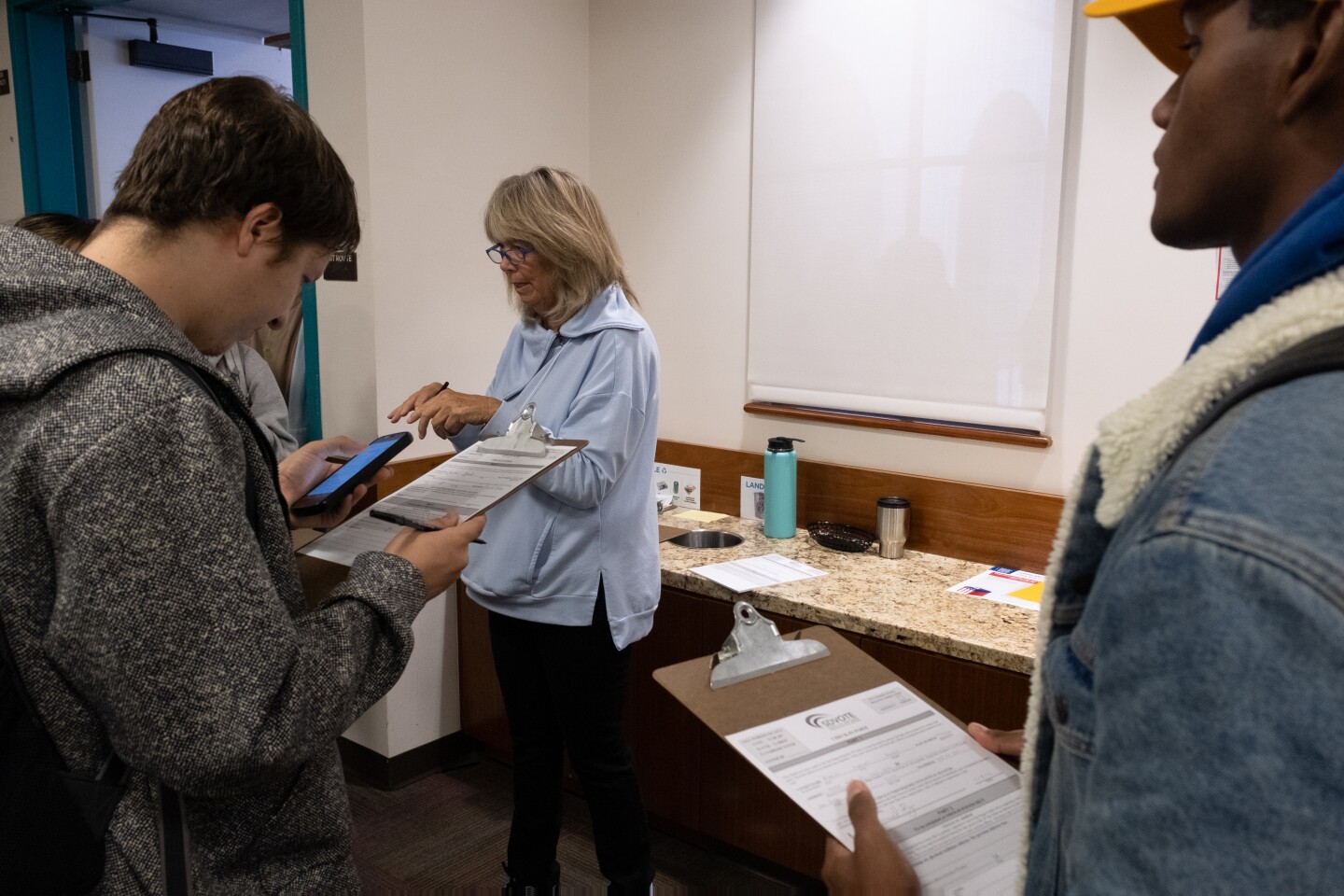 A San Diego County poll worker helps students fill out their same day conditional voter registration in order for them to cast a provisional ballot at San Diego State University, Nov. 8, 2022.