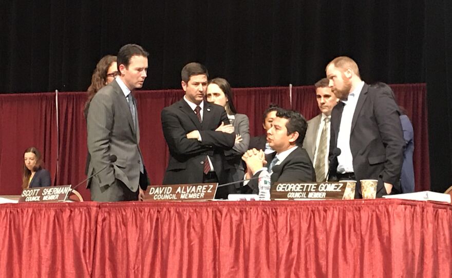 San Diego City Councilmen Mark Kersey (left) and Chris Ward (center) look at Councilman David Alvarez (seated) during a recess of a council meeting on short-term home rentals, Dec. 12, 2017.