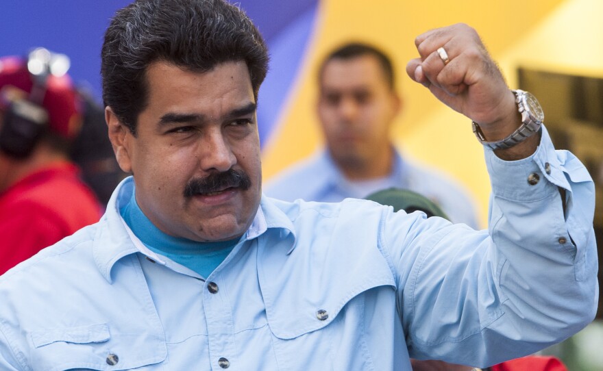 Critics of President Nicolas Maduro, shown here at a Caracas rally on March 18, say that as his popularity sinks, his government has made it a policy to file criminal charges against the political opposition, including many elected mayors.