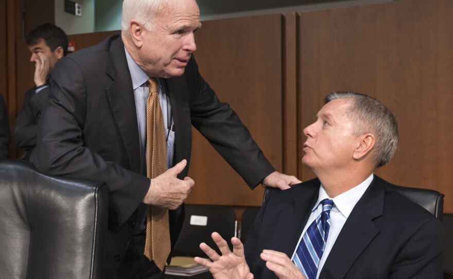 Republican Sens. John McCain of Arizona and Lindsey Graham of South Carolina confer at the start of a Senate Armed Services Committee hearing in July.