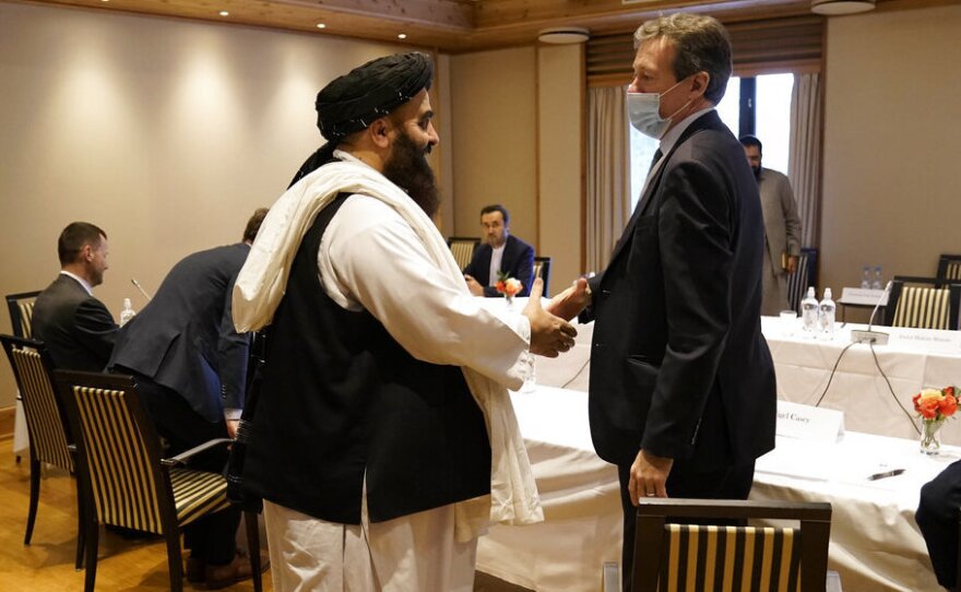 Special Representative for Afghanistan Nigel Casey, right, shakes hands with Taliban representative Amir Khan Muttaqi, centre, ahead of a meeting, in Oslo, Norway, Monday, Jan. 24, 2022.