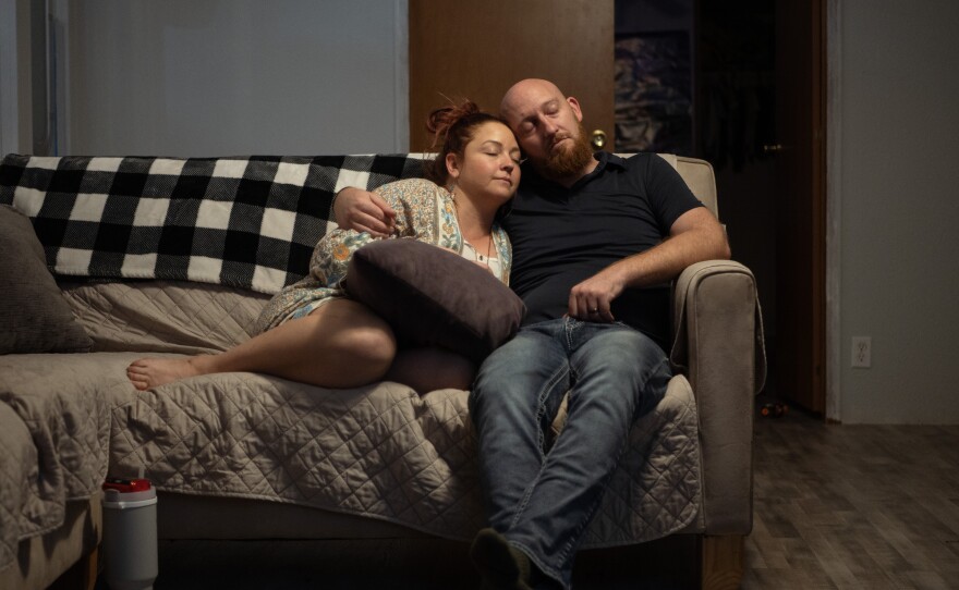 Erica and Wade Hanicker rest together on the couch after putting their two children to bed. Erica Hanicker was the one to insist her husband visit the emergency room when his pain worsened.