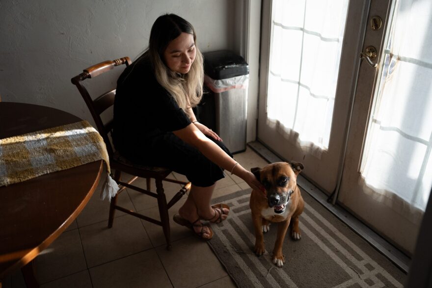 Barajas pets her dog in her dining room on Aug. 22, 2024. 