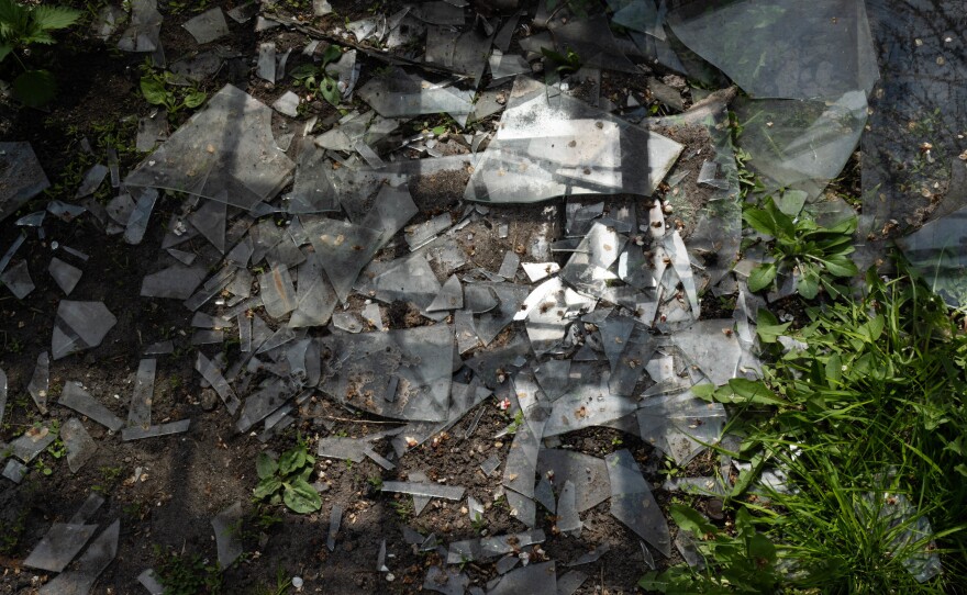 Shattered glass from the Tostopalovs' greenhouse is scattered all over their yard.