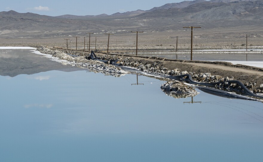 The mountains are reflected in a lithium brine evaporation pool at Silver Peak lithium mine in Silver Peak, Nev. on Oct. 6, 2022.