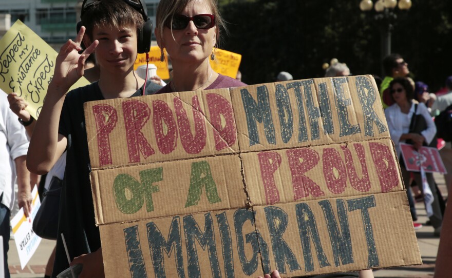 Linda Land-Classon, right, holds up a sign with her 15-year-old son, Ivan, who came to America in 2003 from Vladivostok, Russia, during an immigration rally and protest in Civic Center Park in downtown Denver.