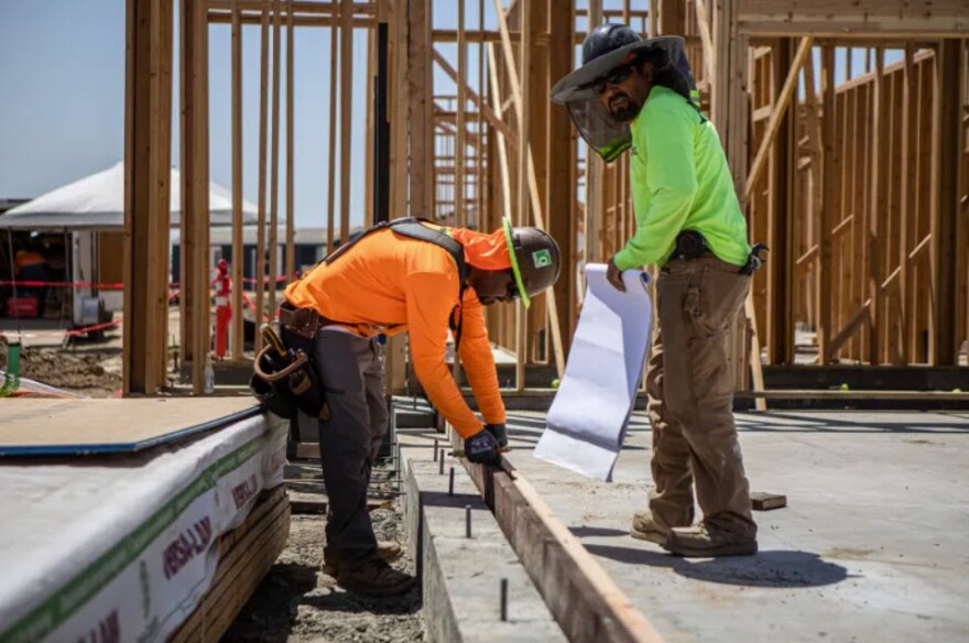 Construction workers on site of a tiny homes village in Goshen on June 2, 2023.