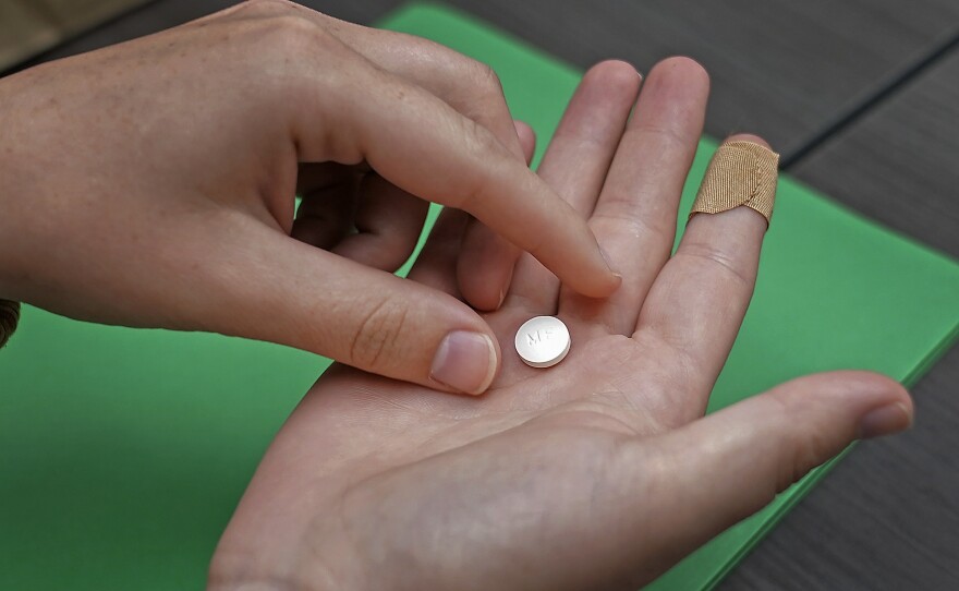 File photo of a patient preparing to take the first of two combination pills, mifepristone, for a medication abortion during a visit to a clinic in Kansas City, Kan., on Oct. 12, 2022. 