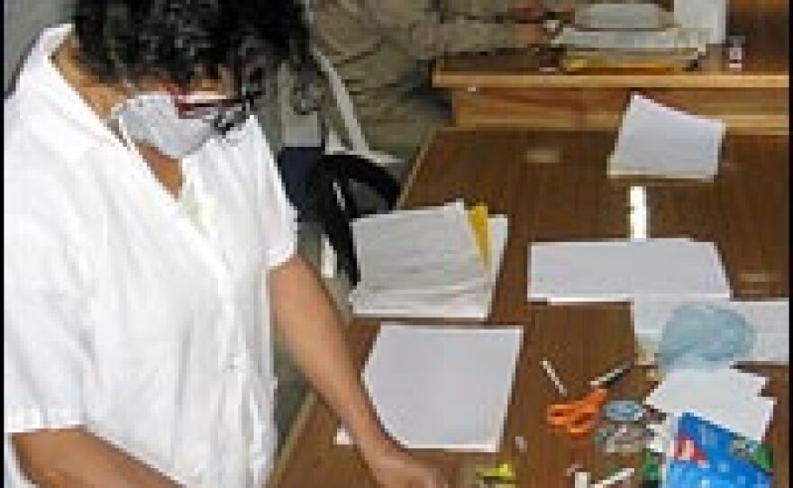 Workers clean documents in the Police Archive, preparing the records for analysis by human rights researchers.