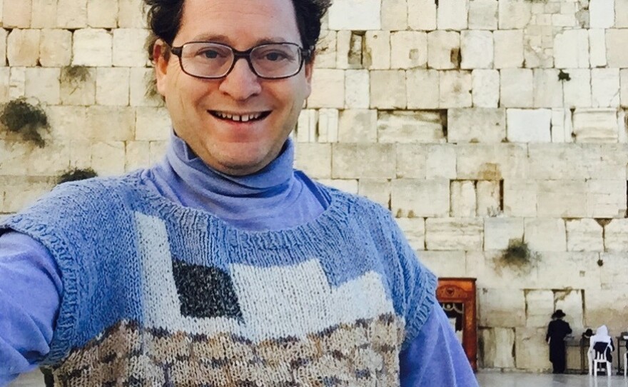 The knitter flashes a smile at Jerusalem's Western Wall.