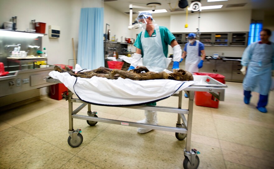 Pathologist examines a body found in the desert.