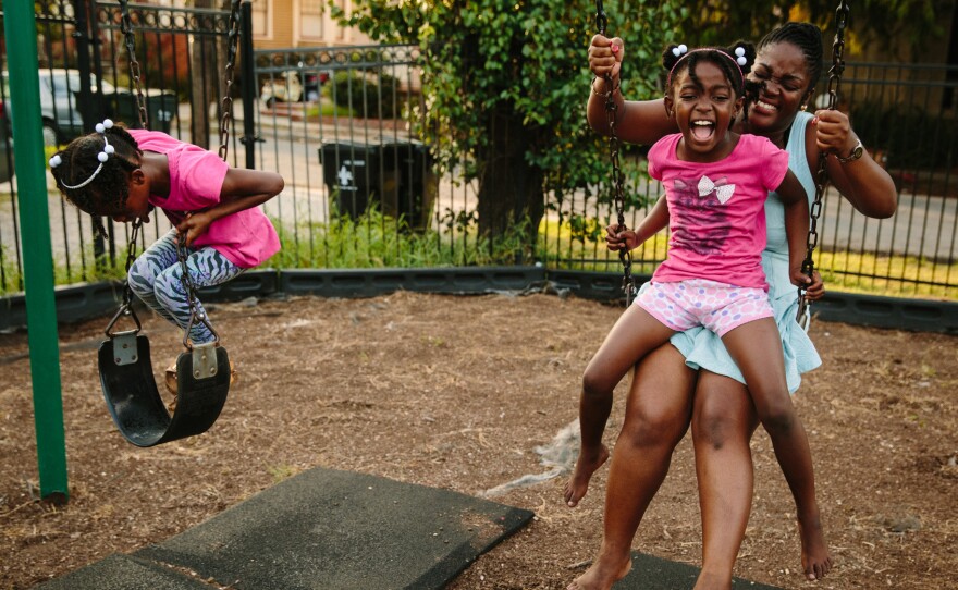 Briceshanay Gresham laughs with her daughter Uri (wearing shorts) and sister Dyha. Ten years after escaping Katrina, Gresham teaches elementary school in New Orleans and is studying to become a music therapist.