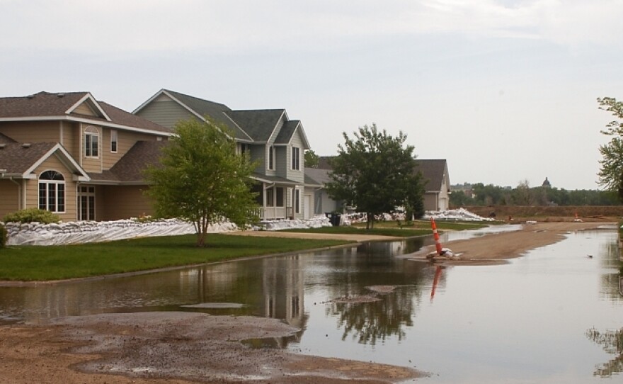 Water pools in the street in front of sandbagged homes in Pierre, S.D., Thursday. South Dakota's governor has urged some residents to evacuate from three cities considered early trouble spots as officials brace for a prolonged period of Missouri River flooding