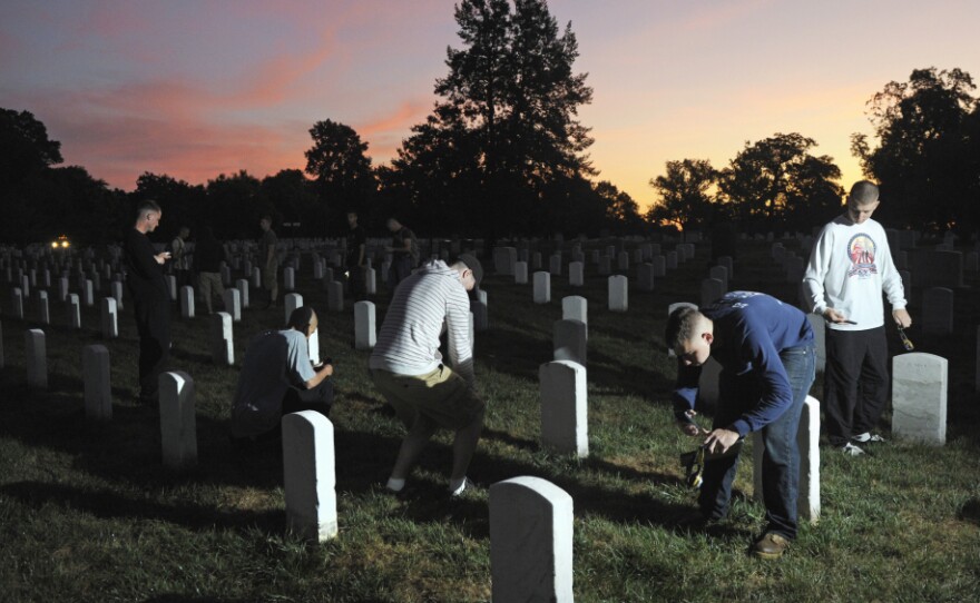 The sun rises over Section 15 at Arlington National Cemetery as soldiers from the Army Old Guard photograph headstones on Aug. 24. Their work is part of a task force to photograph and catalog nearly 220,000 grave markers and the columbarium niches of more than 43,000 sets of cremated remains at Arlington.