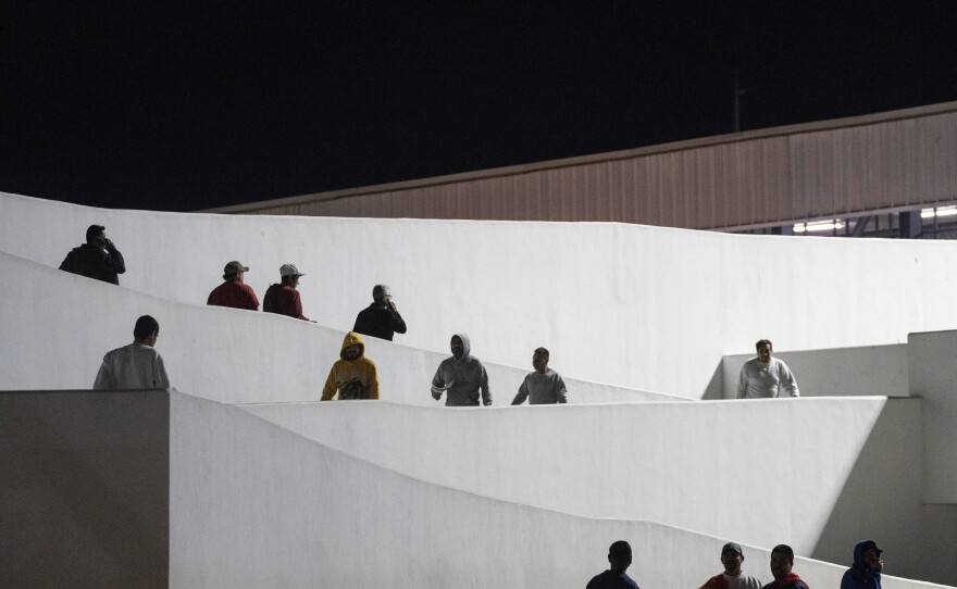 Migrants walk into Mexico after being deported from the U.S. at El Chaparral pedestrian border bridge in Tijuana, Mexico, Tuesday, Jan. 21, 2025.