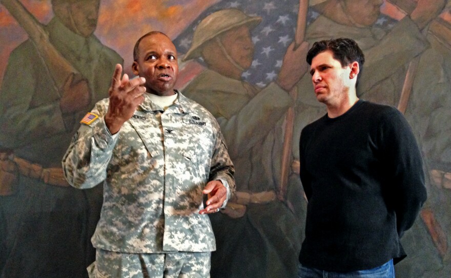 Col. Reginald Sanders, former commander of the 369th Sustainment Brigade, and The Harlem Hellfighters author Max Brooks tour the 369th Regiment Armory in New York City.