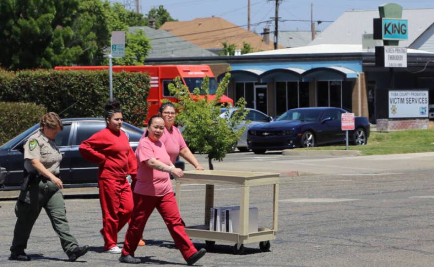 Immigrant detainees help a sheriff’s deputy carry items to a truck outside the Yuba County Jail in this undated photo.