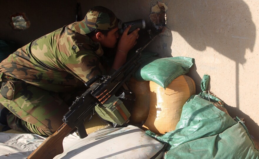 An Iraqi Sunni fighter holds a position during clashes with Islamic State group fighters in October the town of Dhuluiyah.