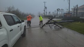 A utility pole blocks the road in Saipan on Wednesday as a super typhoon with ferocious winds and relentless rains, shredded tin roofs and forced residents to take cover from flying tree limbs.