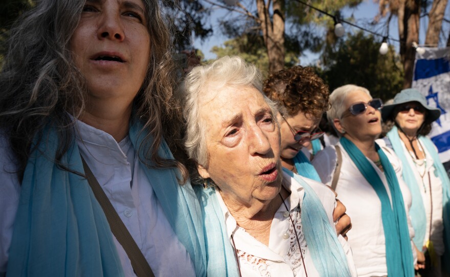 Members of the Women Wage Peace organization sing together as hundreds of mourners gather for the funeral service Thursday.