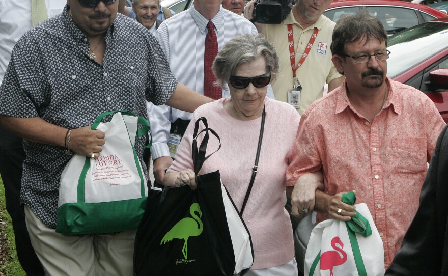 Powerball winner Gloria C. Mackenzie, 84, leaves the lottery office escorted by her son Scott (right) after claiming a single lump-sum payment of just over $370 million before taxes on Wednesday in Tallahassee, Fla. Officials say she is the largest sole lottery winner in U.S. history.