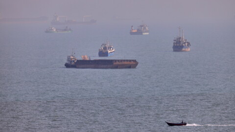 FILE - A small boat sails past cargo ships and other commercial vessels anchored in the Strait of Hormuz off Bandar Abbas, Iran, Wednesday, Aug. 5, 2026. (Amirhosein Khorgooi/ISNA via AP, File)