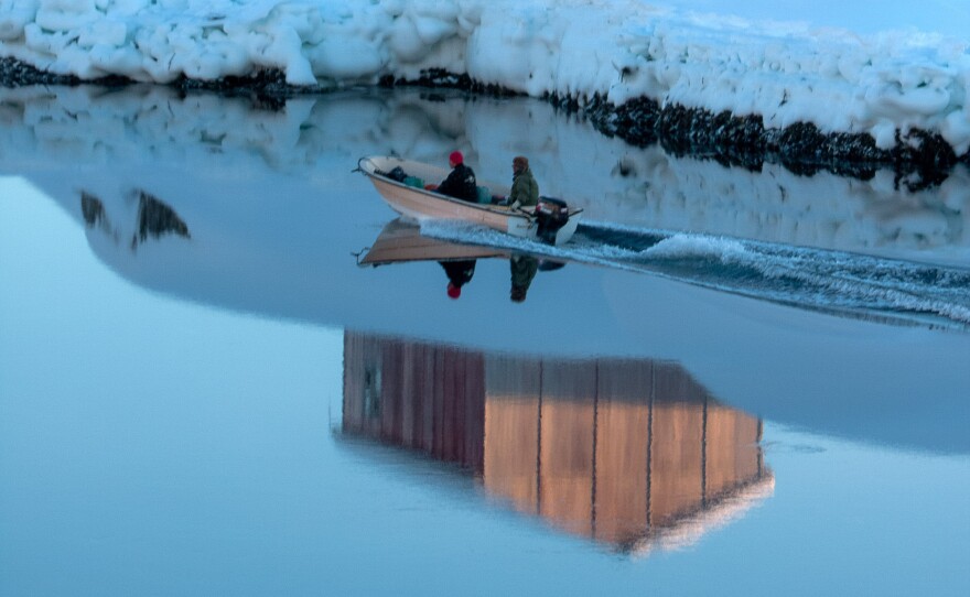 Jægere på vej ud mod havet i en motorbåd i Tiniteqilaaq, Grønland.