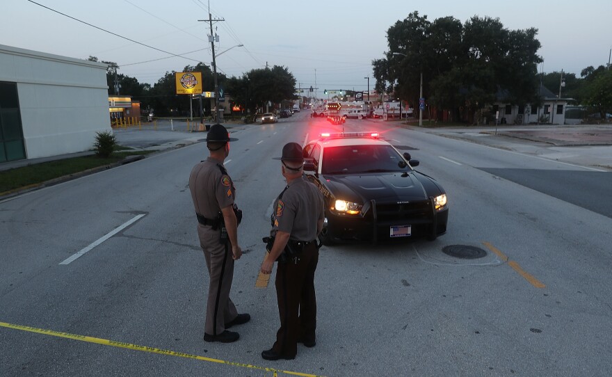 Law enforcement officials block off the road near Pulse nightclub on June 15 as they continue the investigation into the shooting there. The Justice Department on Monday released a transcript of a 911 call that Omar Mateen made the night of the shooting.