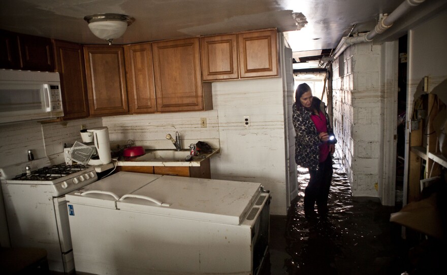 Jackie Hoey inspects the first floor of her Long Beach, N.Y., home, which experienced heavy flooding.