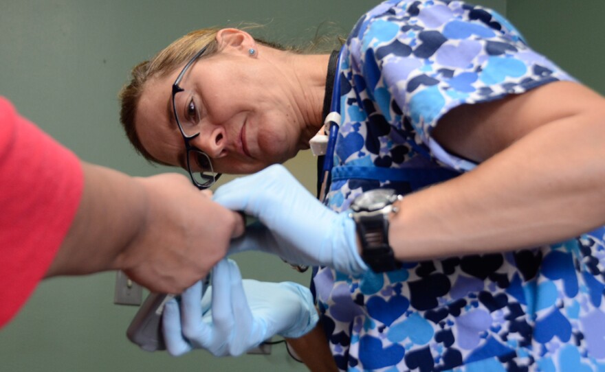 Laura Hamilton, RN, checks a diabetic patient's blood sugar at the Free Clinic of Simi Valley on Thursday, March 7, 2013. The registered nurse is a volunteer at the clinic that seeks to keep patients away from expensive modes of care like the emergency room.