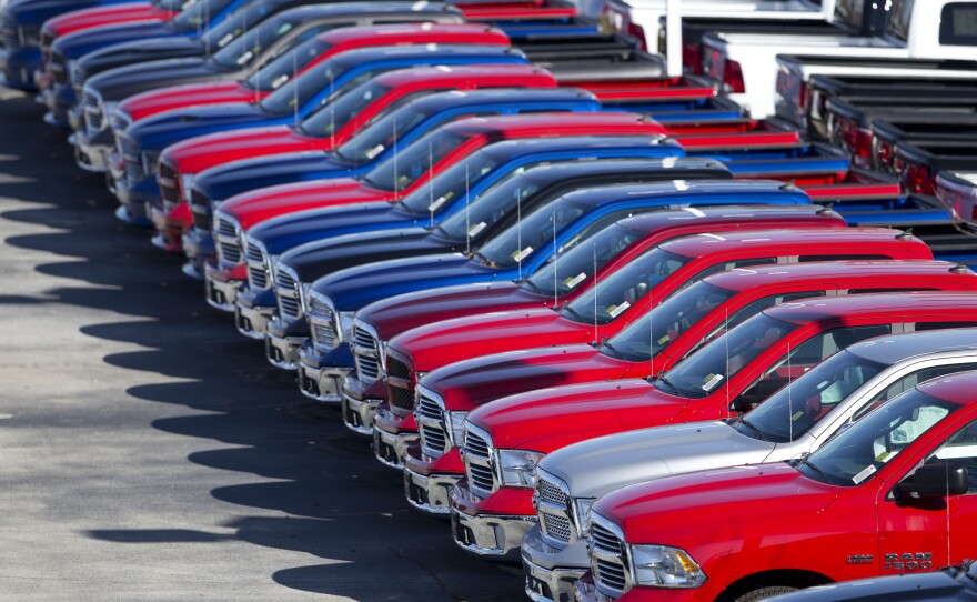 Dodge Ram pickup trucks await customers Jan. 5 on the lot at Landmark Dodge Chrysler Jeep in Morrow, Ga. Buoyed by a resurgent economy, holiday sales, cheap gasoline and a love affair with pickup trucks, Americans headed to car dealers in droves last month, pushing full-year sales to what's likely to be the highest level since 2006.