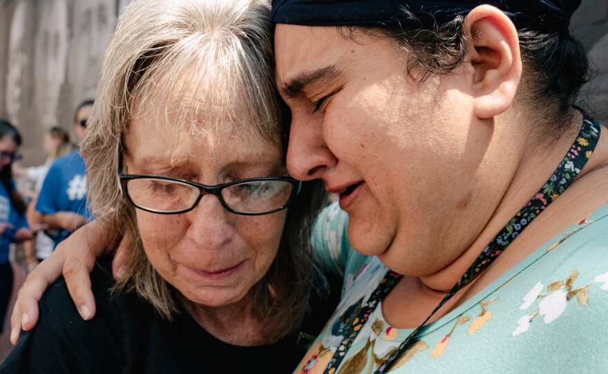 Connie Haynes embraces Tejkaran Kaur Bains at the unveiling of a mural featuring the faces of Americans who are wrongfully detained. More than five dozen Americans are being held hostage or wrongfully detained abroad, according to a count by the James. W. Foley Legacy Foundation.