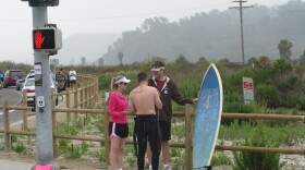 A surfer stops to sign a petition in support of state parks on his way into Torrey Pines State Reserve.
