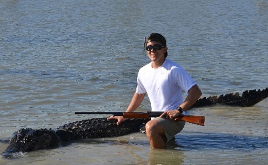 A photo provided by the Texas Parks and Wildlife Department shows Braxton Bielski with the 800-pound alligator he killed.