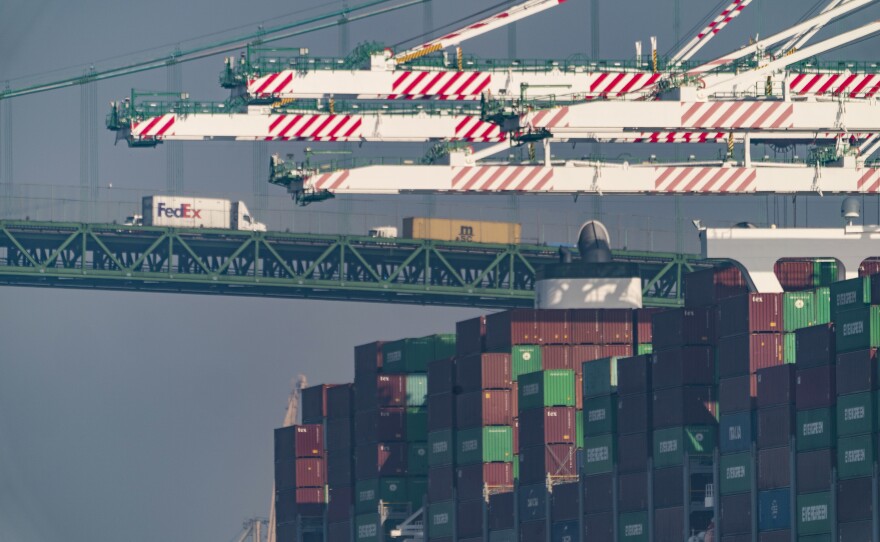 File photo of transportation trucks crossing the Vincent Thomas Bridge over the main channel as shipping containers are seen stacked on the Evergreen terminal at the Port of Los Angeles in San Pedro, Calif., Nov. 30, 2021.