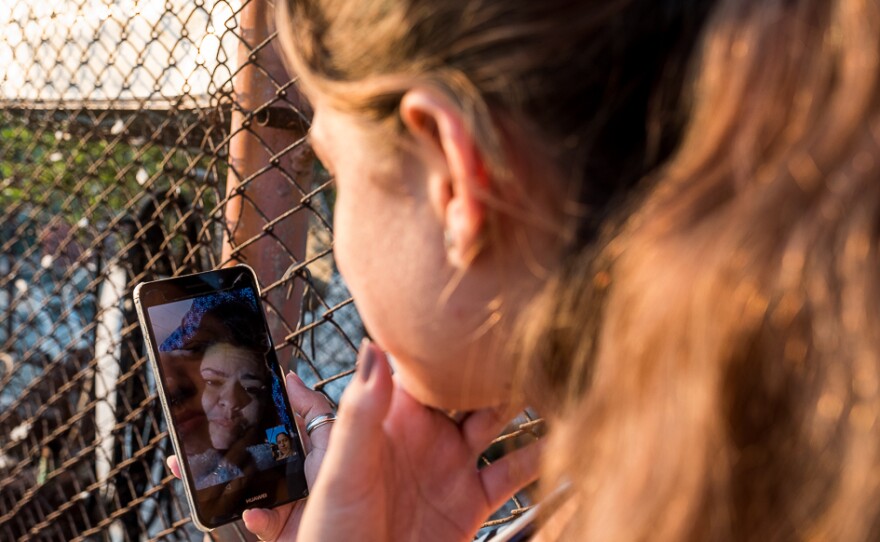 Laura and Maidel chat via video call.