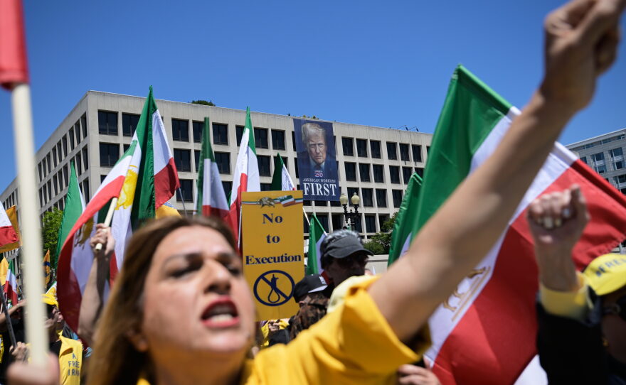 A banner of President Donald Trump hangs over Iranian Americans and their supporters as they march from the U.S. Capitol to the World War II Memorial during a rally Saturday, May 16, 2026, in Washington.