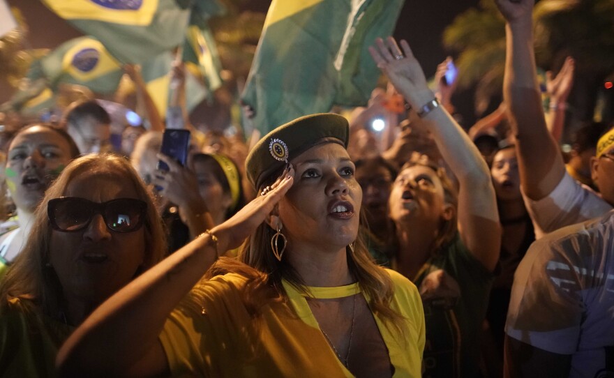 A supporter of Jair Bolsonaro salutes during a celebration in front of his residence after he was declared the winner of the election runoff, in Rio de Janeiro, on Sunday.