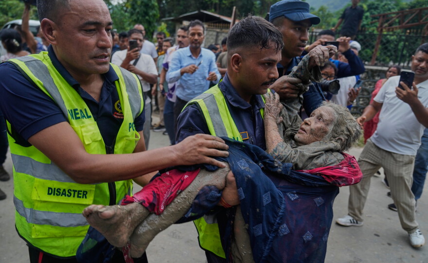 Rescuers carry a victim of flash flooding to safety along the Trishuli River in Nepal's Nuwakot district, Wednesday, Aug. 26, 2026.