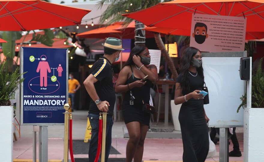 People leave the Ocean 10 restaurant as a curfew from 8 p.m. to 6 a.m. is put in place on Saturday in Miami Beach, Florida.