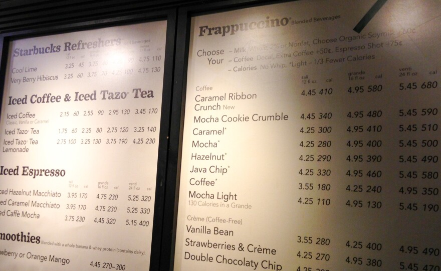 A menu board shows calorie counts hangs at a Starbucks in New York City. The FDA had previously halted the roll out of rules requiring chain restaurants and other food establishments to post calories on menus. Now, the agency says the rules will be in place by May 2018.