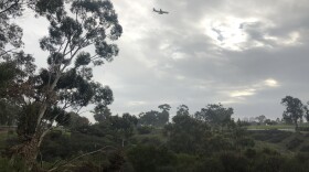 A plane flies through light rain over the Balboa Park Golf Course, Jan. 15, 2019.