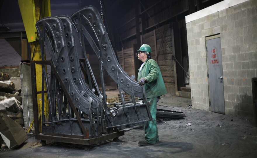 Dan Hensley lines up piano plates just removed from the molds, now off for finishing and painting.