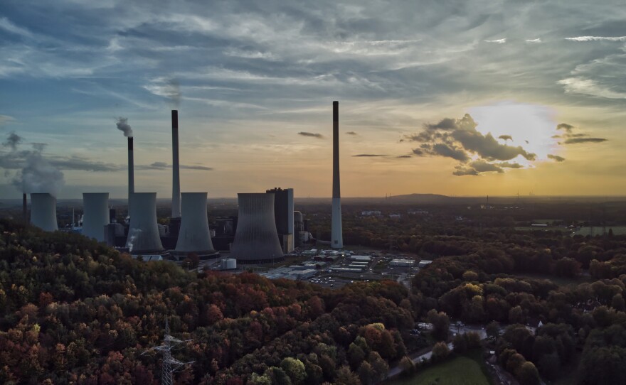 The sun sets behind a coal-fired power plant in Gelsenkirchen, Germany, Oct. 22, 2022. A new report from doctors and other health experts says the world's fossil fuel addiction is making the world sicker and is killing people.