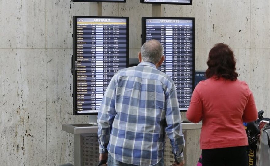 Passengers check their flight status at Los Angeles International Airport