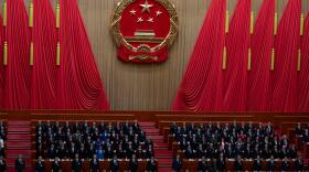 Delegates including Chinese President Xi Jinping (center) stand as the national anthem is sung during the closing session of the National People's Congress at the Great Hall of the People in Beijing, Thursday.
